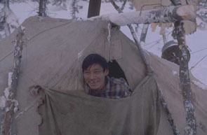 Napaen Rich peers from the door of his tent at Kauinipishit namesh. The group was close to starvation at this point, but killed caribou soon after arriving here. Photo courtesy Georg Henriksen.