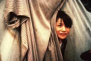 Shak Penashue peers through the tent door at Enakapeshakamau. Photo Nigel Markham, courtesy Innu Nation.