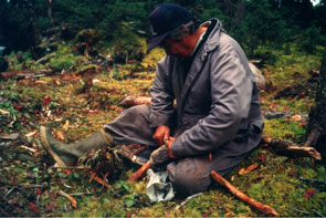 Ishpashtien Penunsi demonstrating the use of a caribou-bone hide scraper at Mishtashini, archaeological survey. Photo courtesy Fred Schwarz.